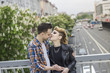 © yurolaitsalbert - portrait of loving couple standing on bridge in big city