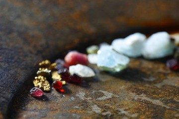 Canvas Print - Uncut gemstones and nuggets of gold from Lapland, displayed on a rusty gold pan