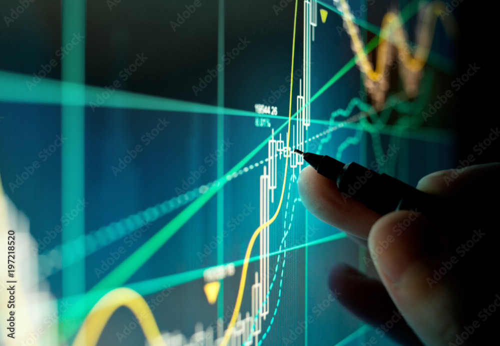 A stock trader checking technical markers of a stock on a computer screen. - obrazy, fototapety, plakaty 