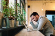 © bnenin - Worried man looking at laptop screen while sitting at modern cafe.