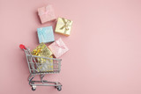 Fototapeta Mapy - Colorful gifts box, supermarket shopping cart on pink background