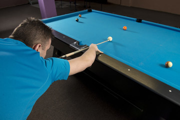 Wall Mural - Back side shot of a pool player ready to hit white cue ball on a billiard table.