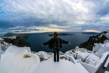 Chica en los edificios de Santorini  Grecia, contemplando un atardecer