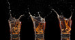 set of whiskey shots with splash isolated on black background