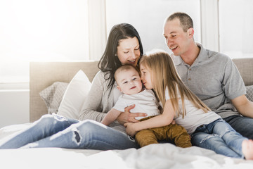 happy family on white bed in the bedroom