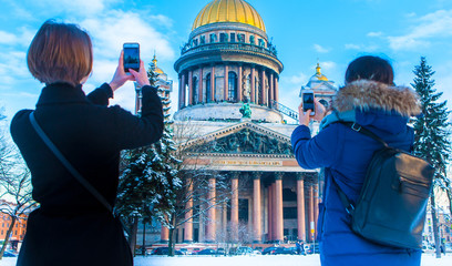 Wall Mural - Saint Petersburg. Cities of Russia. Architecture of Petersburg. Tourists take pictures of the sights of the city of Petersburg. The girl is taking pictures of the museum in St. Petersburg. Russia.