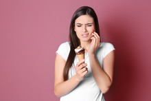 Young Woman With Sensitive Teeth And Cold Ice Cream On Color Background