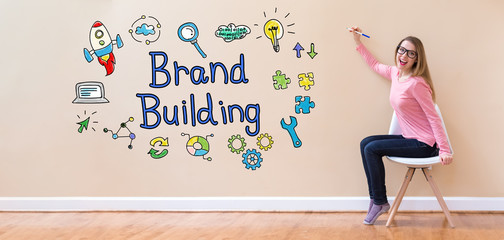 Wall Mural - Brand Building with young woman holding a pen in a chair