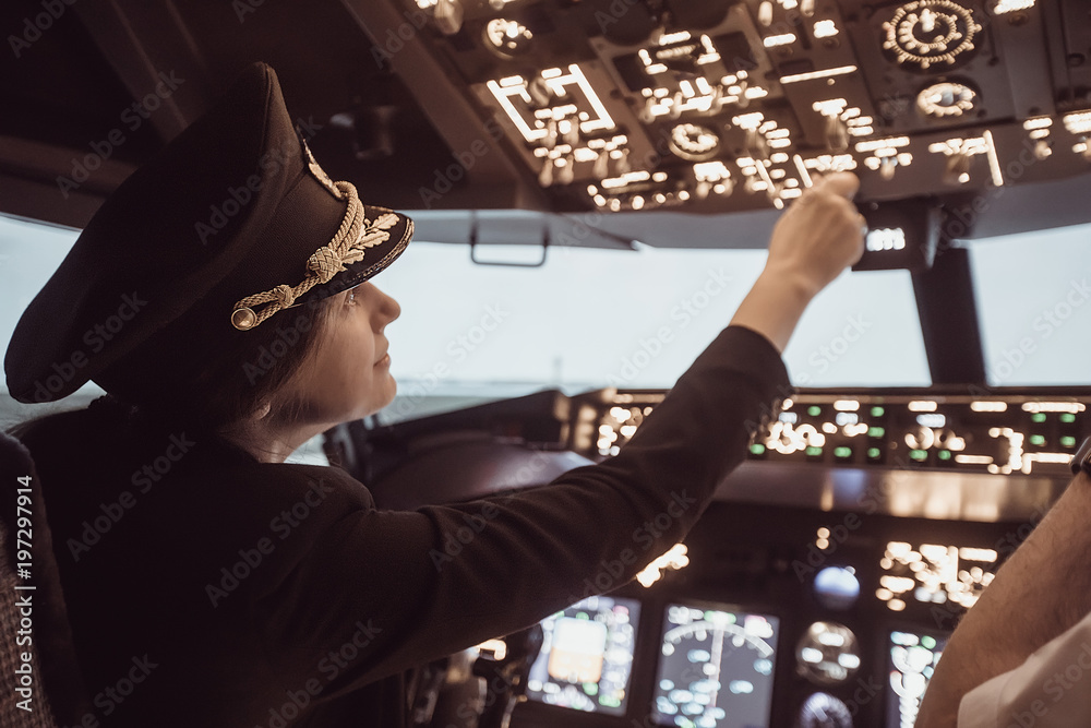 Female pilot the captain of the plane prepares for take-off in the plane cockpit. Girl pilot in uniform flying craft plane in the sky - obrazy, fototapety, plakaty 