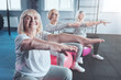 © Viacheslav Yakobchuk - Healthy retirement. Motivated elderly ladies beaming while sitting on colorful fitness balls with their hands outstretched in front and doing fitness exercises in a gym.