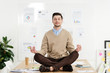 © LIGHTFIELD STUDIOS - relaxed businessman with eyes closed sitting in lotus position on table in office
