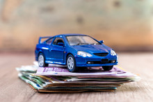Blue Toy Car With Euro Bills On Desk