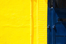 Yellow Wall And Blue Metal Door Background