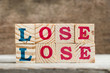 Letter block in word lose lose on wood background