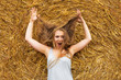 © AnastazjaSoroka - A smiling young woman with a blond with disheveled hair on the background of hay. Copy space. Nasty hair concept.