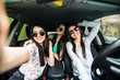 © F8  \ Suport Ukraine - three young cheerful women making selfie and smiling while sitting in car together