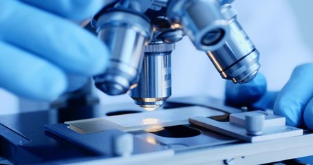 scientist hands with microscope close-up shot in the laboratory