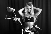 Portrait Of A Beautiful Blonde On A Motorcycle On A Black Background, Black And White Photo. Black And White Portrait Of A Girl