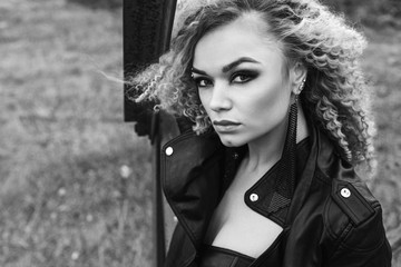 portrait of a beautiful blonde in a leather jacket with a make-up and hairstyle. beautiful and sexy model. black and white photo. monochrome