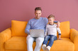 © New Africa - Little boy and his father with laptop sitting on sofa, indoors