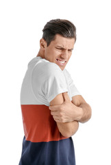 Young man suffering from pain in arm on white background