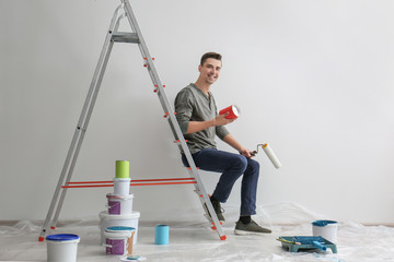 Sticker - Male decorator sitting on ladder in empty room