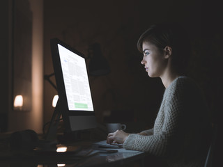 Wall Mural - Woman using a computer at night