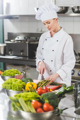 Wall Mural - attractive chef cutting vegetables at restaurant kitchen
