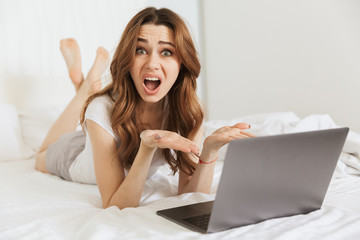 Canvas Print - Portrait of a confused young woman lying in bed at home