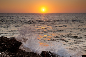 Wall Mural - Wave crashing at sunset