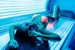 a luxurious young girl in a bathing suit sunbathing in a horizontal solarium under the ultraviolet rays