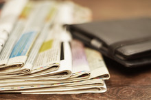 Old Newspapers And E-book. Folded Newspapers And Modern Electronic Book. Daily Papers With News And E-reader Device In Leather Case On Table, Side View, Close Up