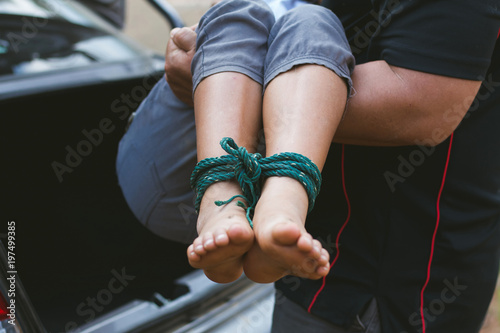 Fotomural little girl with rope tied legs and hands in car,Criminal stealing child in human child traficking concept,children thief,Dangerous in the city