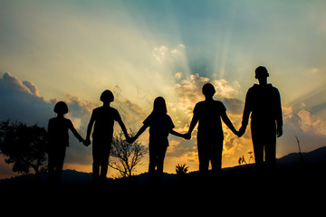 Silhouette group children playing on mountain at sunset time.