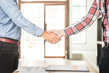 Wall Mural - Two confident business man shaking hands during a meeting in the office, success, dealing, greeting and partner concept.