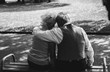 © Vadym - Old couple is sitting on bench in the park. Grandmother and grandfather at their golden wedding anniversary celebration. Fifty years together. Elderly is hugging on the black and white photo.