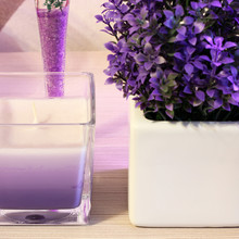 Candle. Violet Decorative Flowers And Stones. Flowers In A Vase