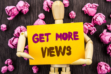Poster - Word, writing, text  Get More Views. Conceptual photo More Traffic Leads Online Page Promotion Popularity Traffic written on Sticky Note Holding By Sculpture on the wooden background.