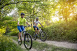 © sergo321 - a woman and a man cycling in summer in the park on bicycles