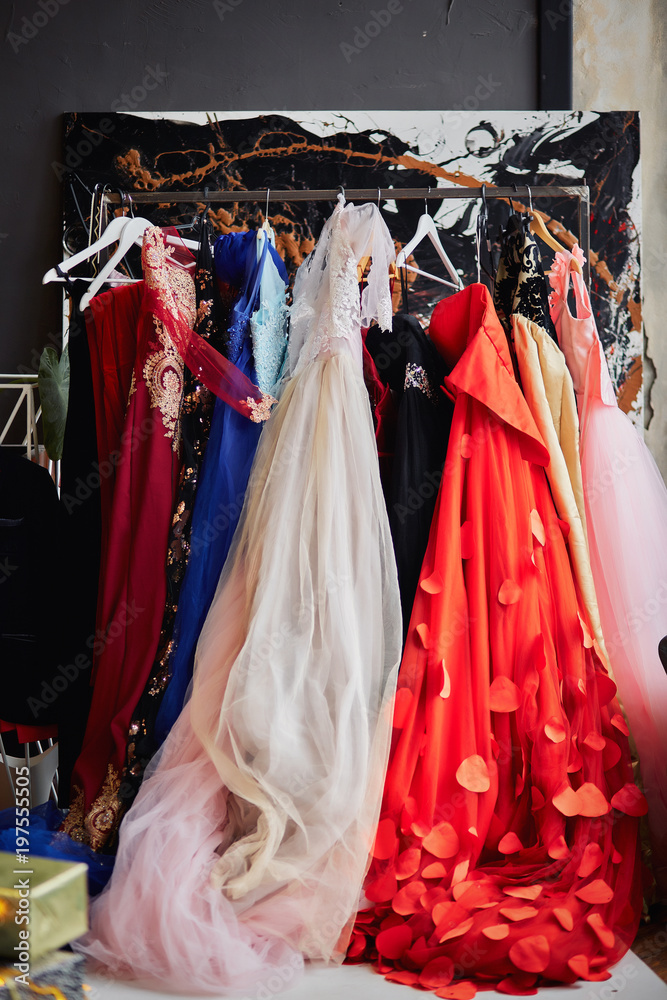 Photo Stock Many ladies evening gown long dresses on hanger in the dress  rent shop for the wedding day or photo session. Dresses rental concept.  Selective focus. Ball gown rental concept. |