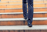 Fototapeta Na drzwi - Business man going up the stairs  in a rush hour to work. Hurry time.