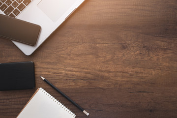 Top view of office wooden desk with Laptop,smartphone and supplies. copyspace