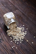 © Aleksey - Overturned glass jar with raw oatmeal on vintage wooden background, close-up, top view, selective focus.