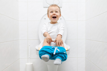 Adorable young child sitting on the toilet