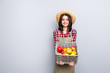 Fruit tree pick buy present show demonstrate market checkered shirt straw hay people person concept. Portrait of kind friendly lady offering to try taste apple isolated on gray background copyspace