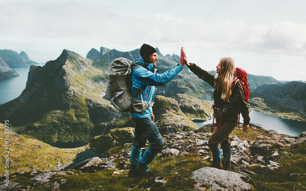 Happy couple giving five hands hiking with backpack in mountains Travel lifestyle adventure concept family together spending active wanderlust vacations - obrazy, fototapety, plakaty 