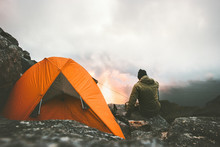 Man Traveler Alone Enjoying Sunset In Mountains Sitting Near Of Tent Camping Gear Outdoor Travel Adventure Lifestyle Concept Hiking Wanderlust Vacations