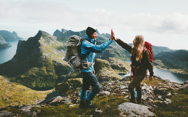 Wall Mural - Happy couple giving five hands hiking with backpack in mountains Travel lifestyle adventure concept family together spending active wanderlust vacations