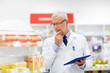 © Syda Productions - medicine, healthcare and technology concept - senior apothecary with tablet pc computer at pharmacy