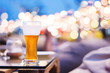 Drinking Alcohol  in Summer Night Party or Event Concept. Glass of Beer on Table. Blurred Light Bokeh as background